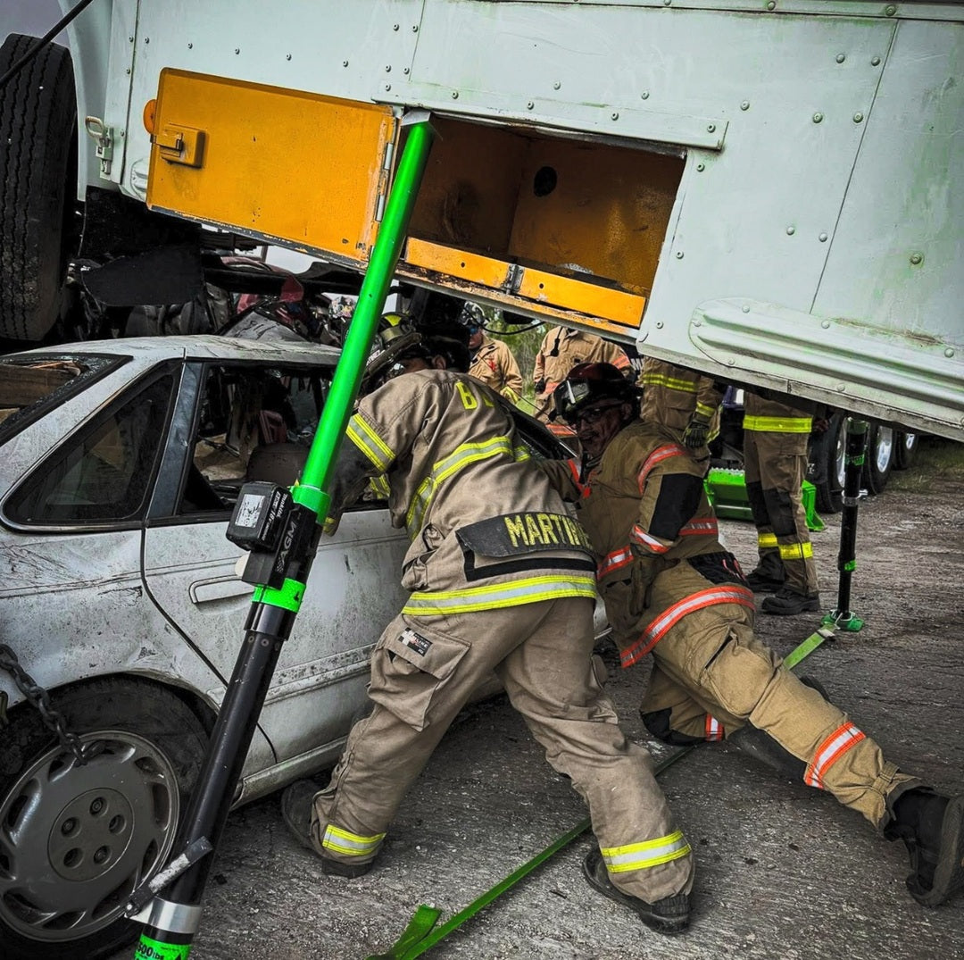 2 Mighty Struts stabilizing a delivery truck that is on top of a passenger car. 