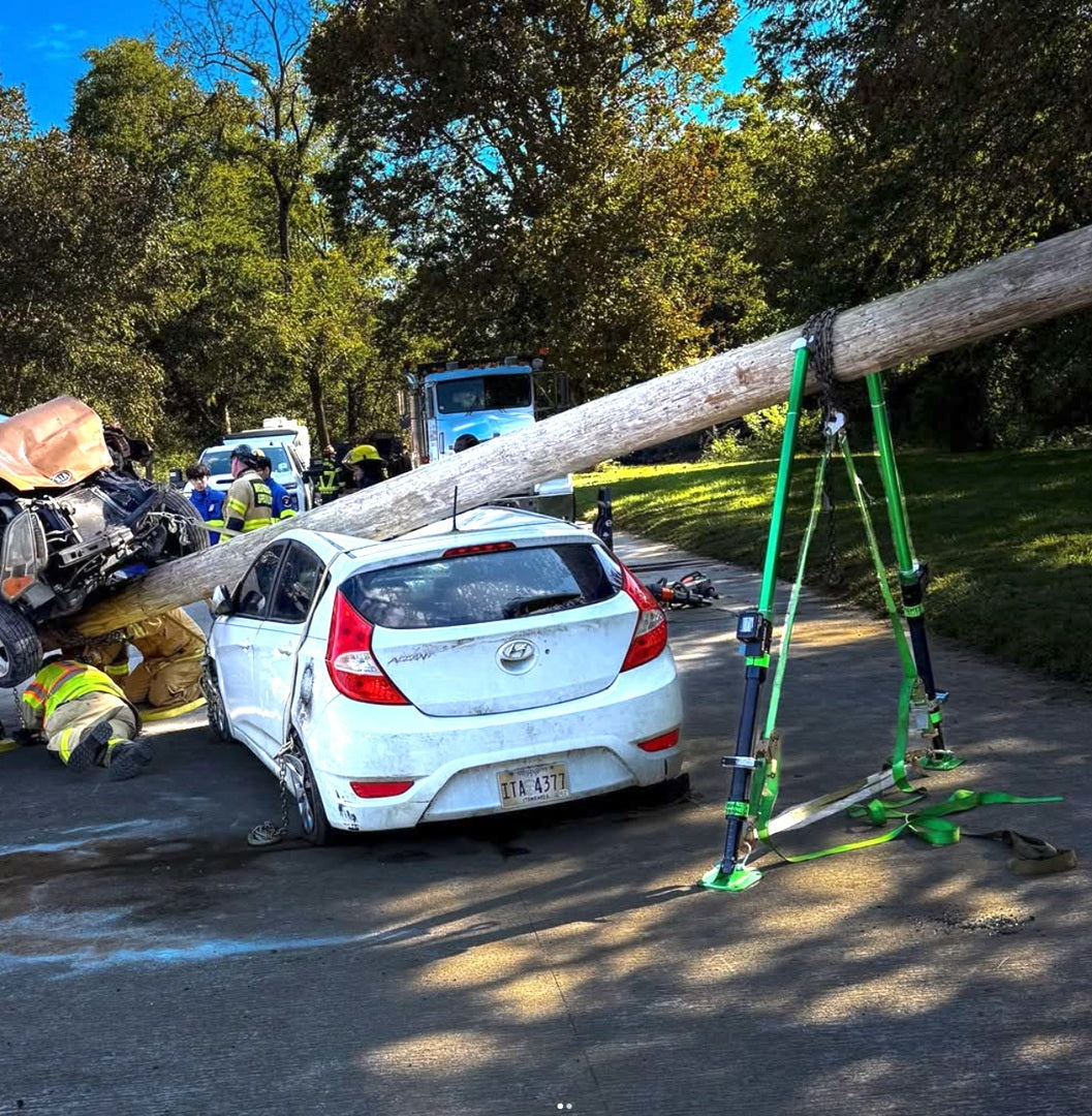 2 Mighty Struts stabilizing a telephone pole that has fallen onto a white car during a rescue. 